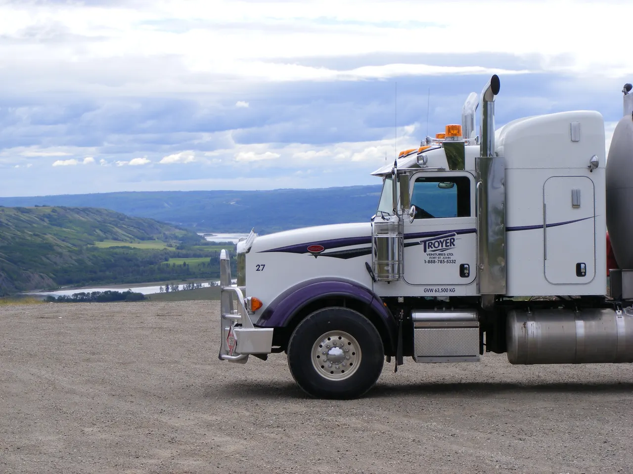 A Troyer truck parked on a bluff above a river valley