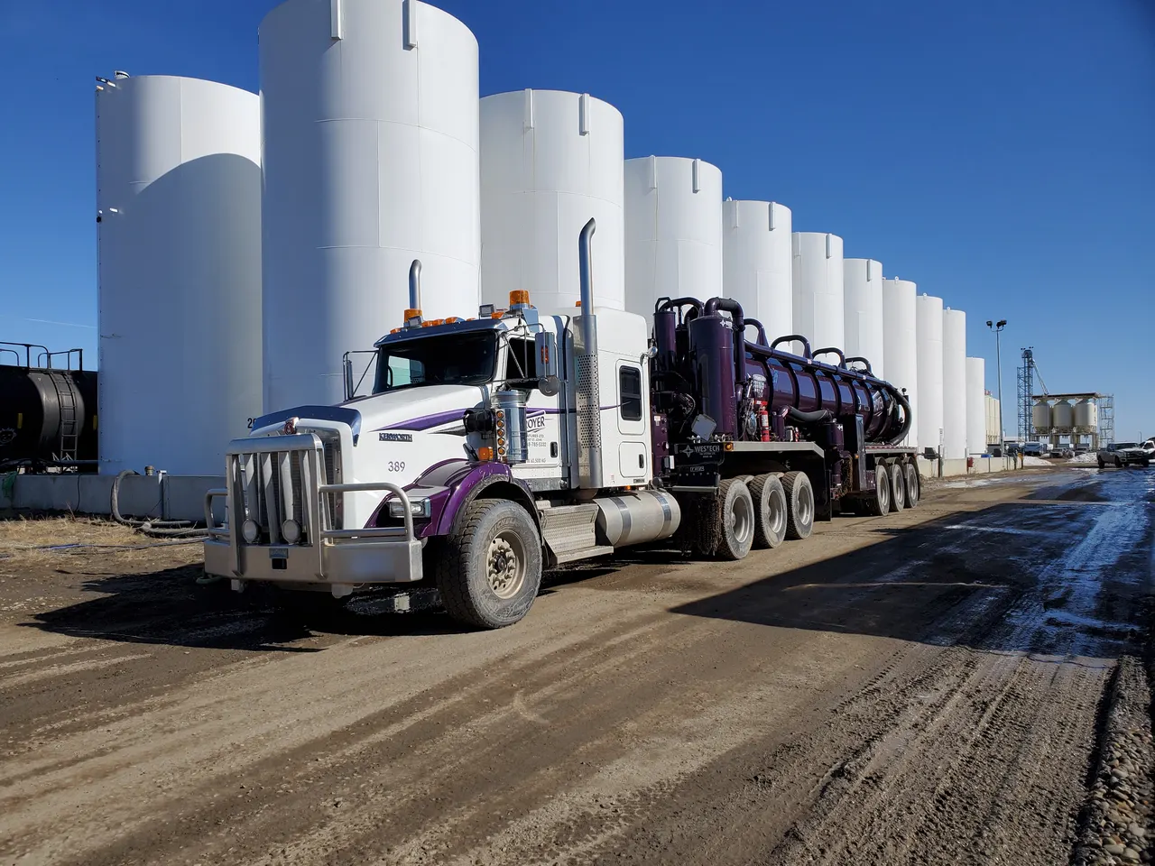 Troyer vac truck 389 parked in front of a row of white storage tanks